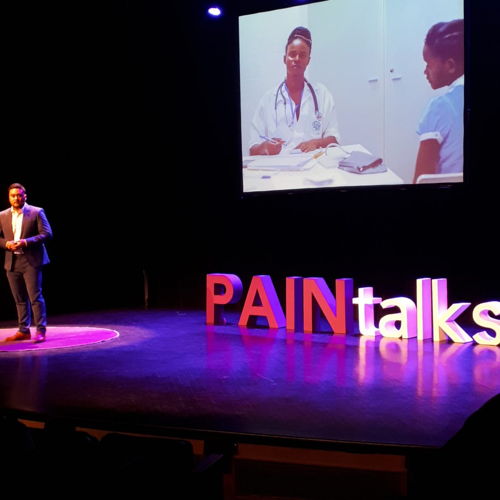 a slide from PAINtalks 2019 showing a girl sitting across from a female physician