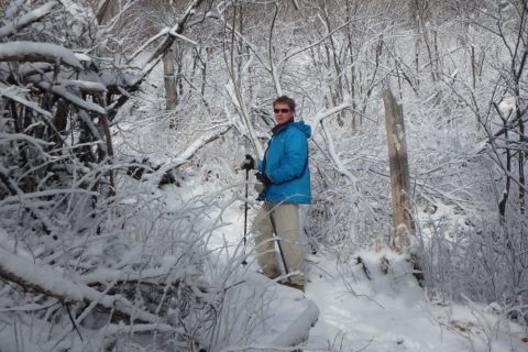 a woman snowshoeing up a steep mountain trail