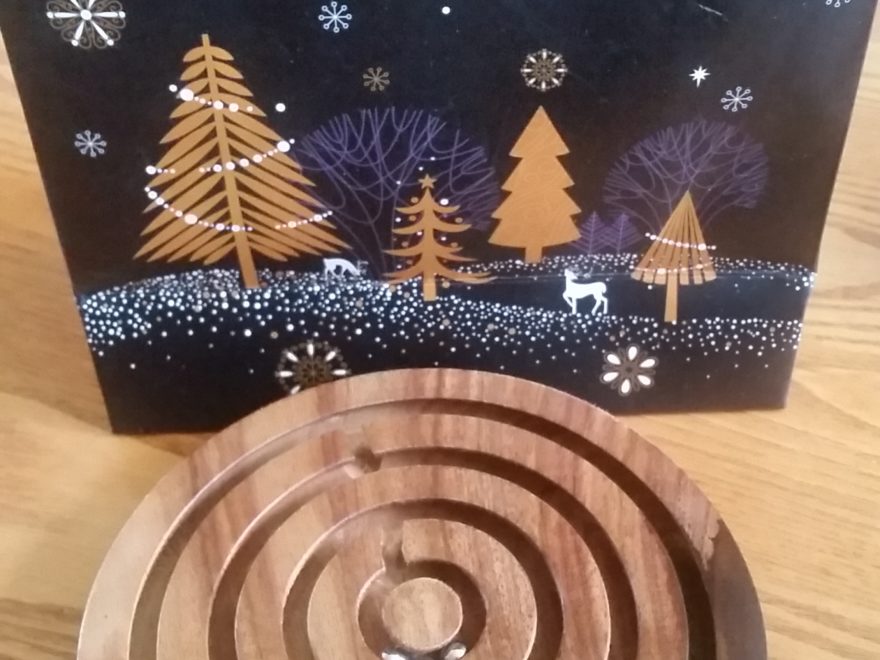 a wooden puzzle toy with a Christmas gift bag