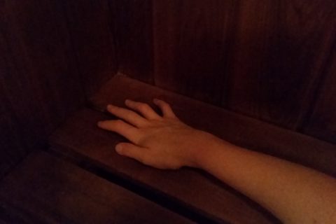 a woman's right hand, lying on the wooden bench of a dry sauna