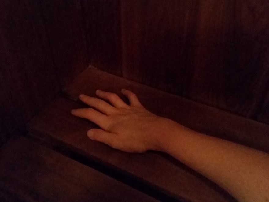 a woman's right hand, lying on the wooden bench of a dry sauna