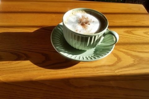 a cup of cappucino on a wooden table