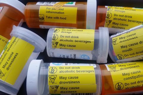 as assortment of 8 pill bottles, showing warnings for drowsiness, dizziness, constipation, dry mouth, etc.