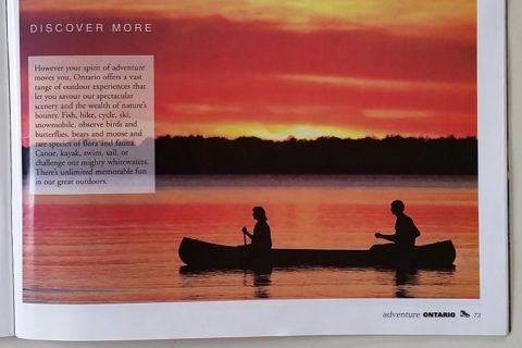a woman and a man canoeing on a lake at sunset