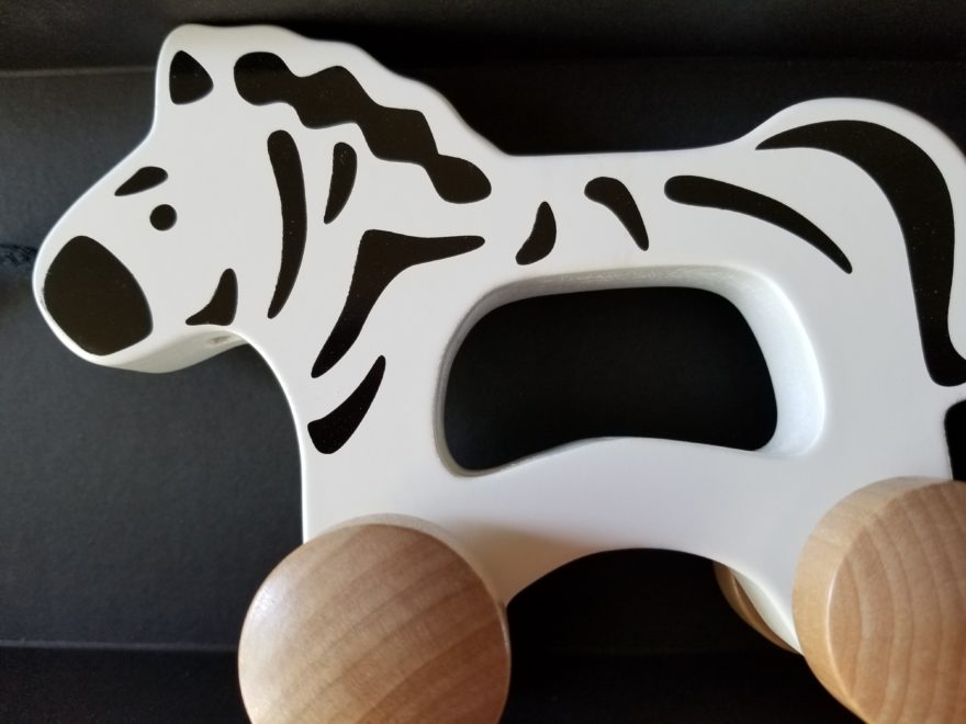 a wooden pull toy, designed to look like a zebra