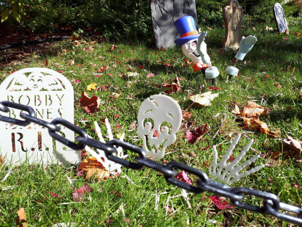 a front yard decorated with fake tombstones, to look like a cemetery for Halloween