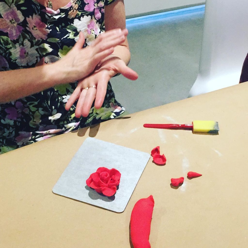 Photo of the blogger, making clay flowers, as art therapy, during an art workshop