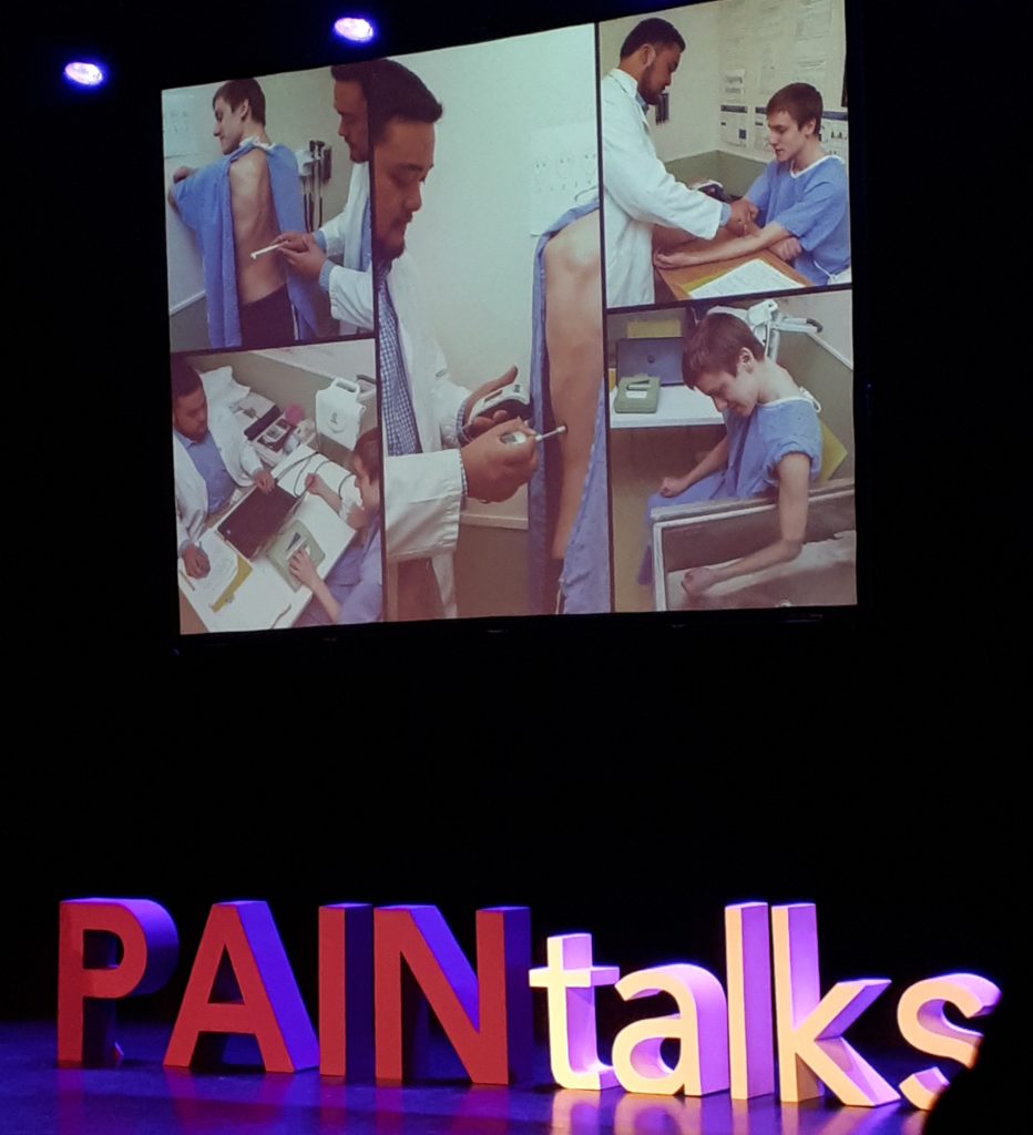 a slide from PAINtalks 2019 showing images of a teenage boy undergoing pain research testing
