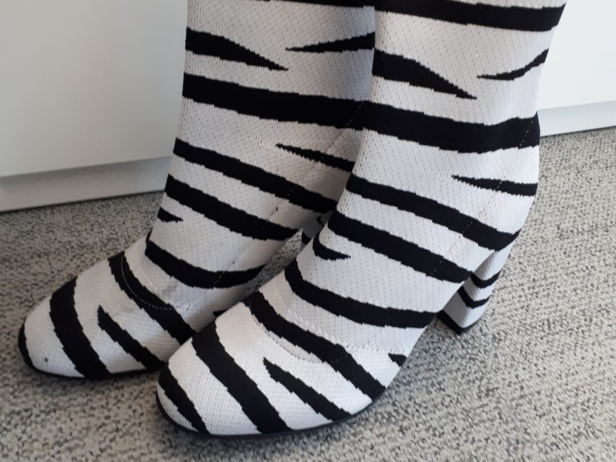 a pair of above-the-ankle boots, with zebra-style stripes imprinted on them