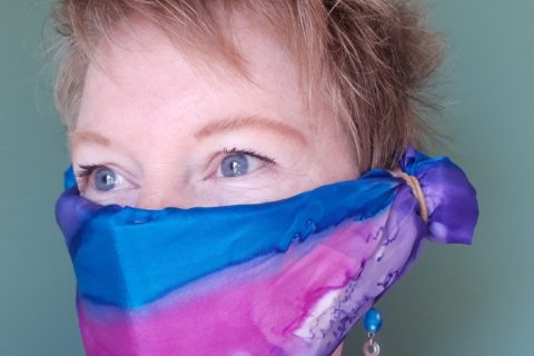 a woman wearing a silk scarf over her nose and mouth