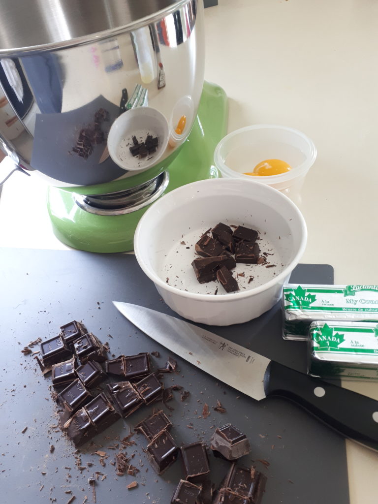 baking ingredients for a chocolate cake, with an electric mixer in the background