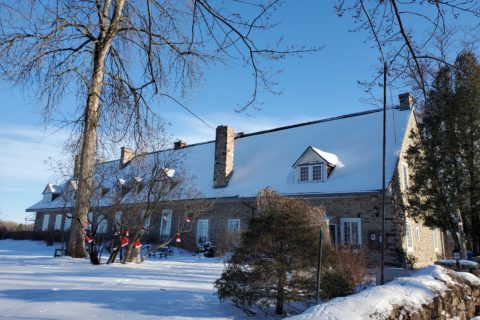A historic stone building, covered in snow