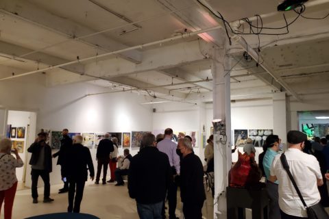 An art gallery filled with people viewing the artworks