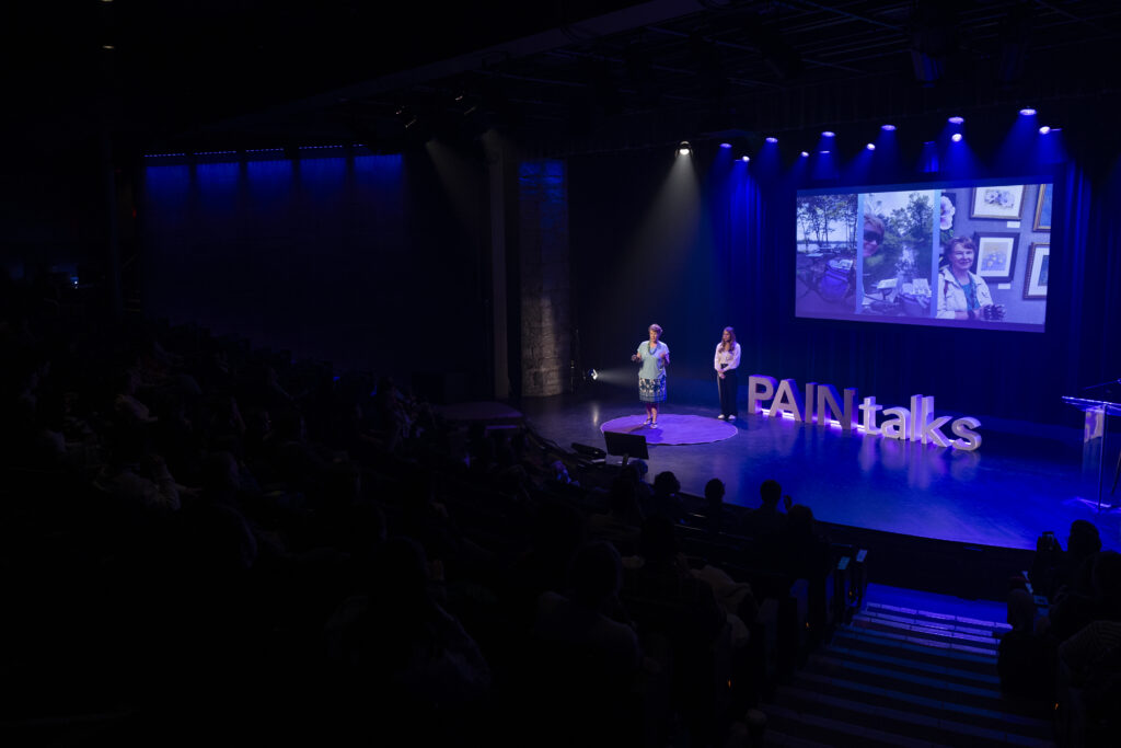 Photo of Dr Zoha Deldar and Sandra Woods onstage at PAINtalks 2024, Nov 7, 2024 at The Gesù in Montréal