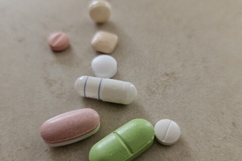 Several pills and capsules, on a kitchen counter