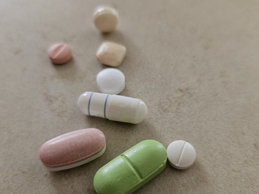 Several pills and capsules, on a kitchen counter